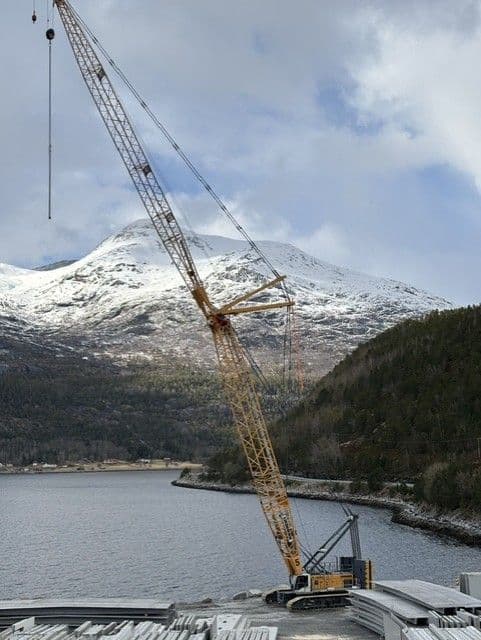 Beltekranen LR 1300 ved en fjord med snødekte fjell i Nordland
