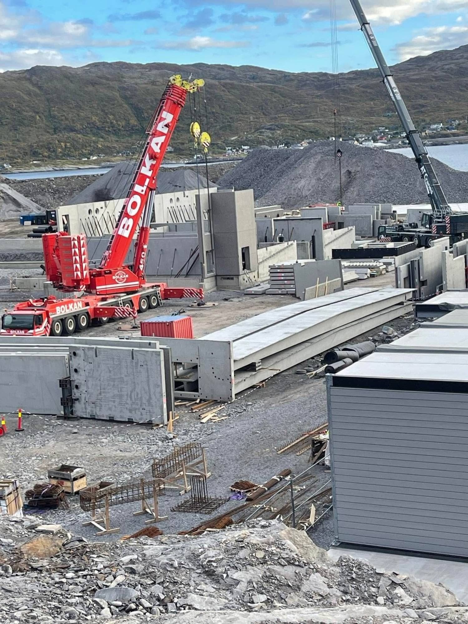 Rød Bolkan mobilkran blant betongelementer på anlegget på Sørøya