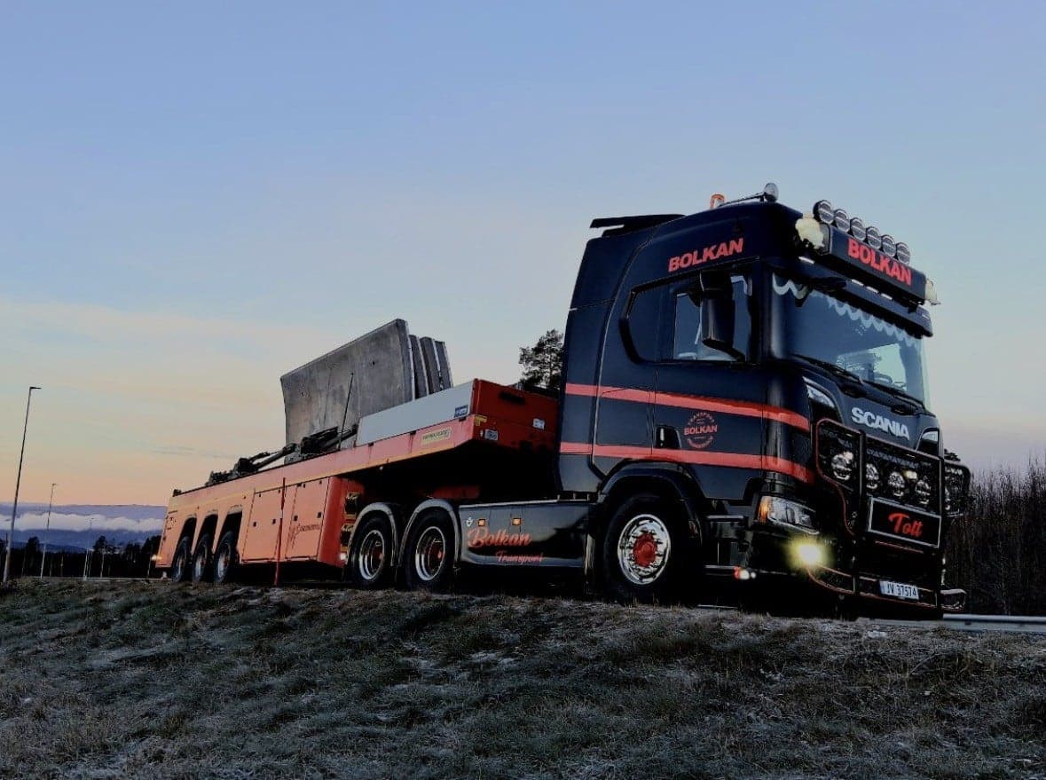 Bolkan Scania med betongelementer på hengeren i skumringen