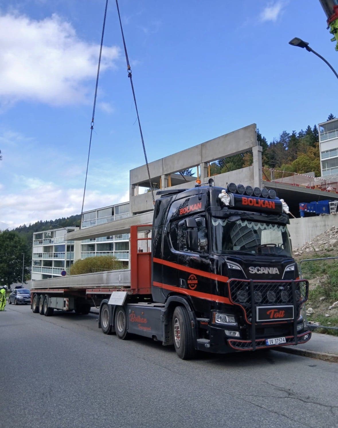 Betongelement løftes av hengeren til en Bolkan Scania på byggeplassen