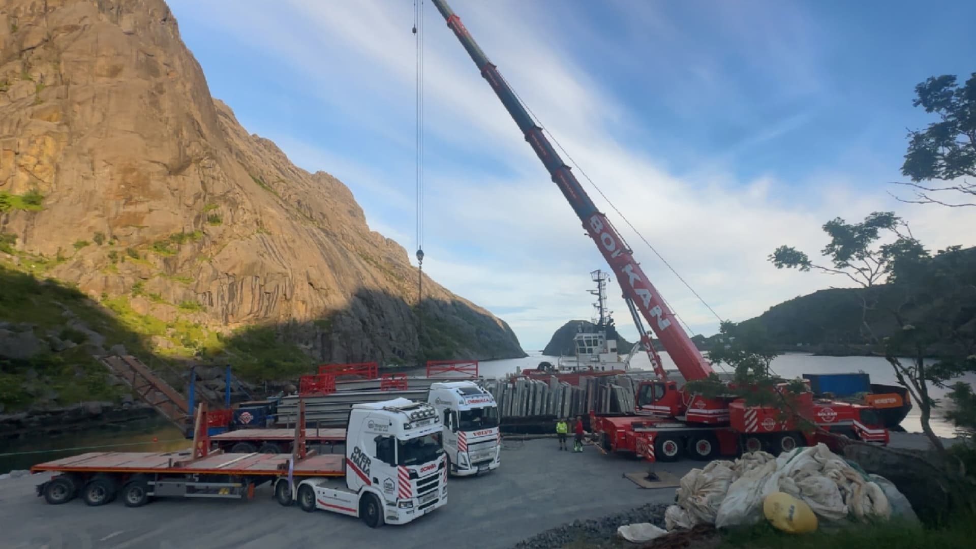 Bolkans 250-tonns mobilkran på en kai under en høy fjellvegg, med betongelementer og en lekter