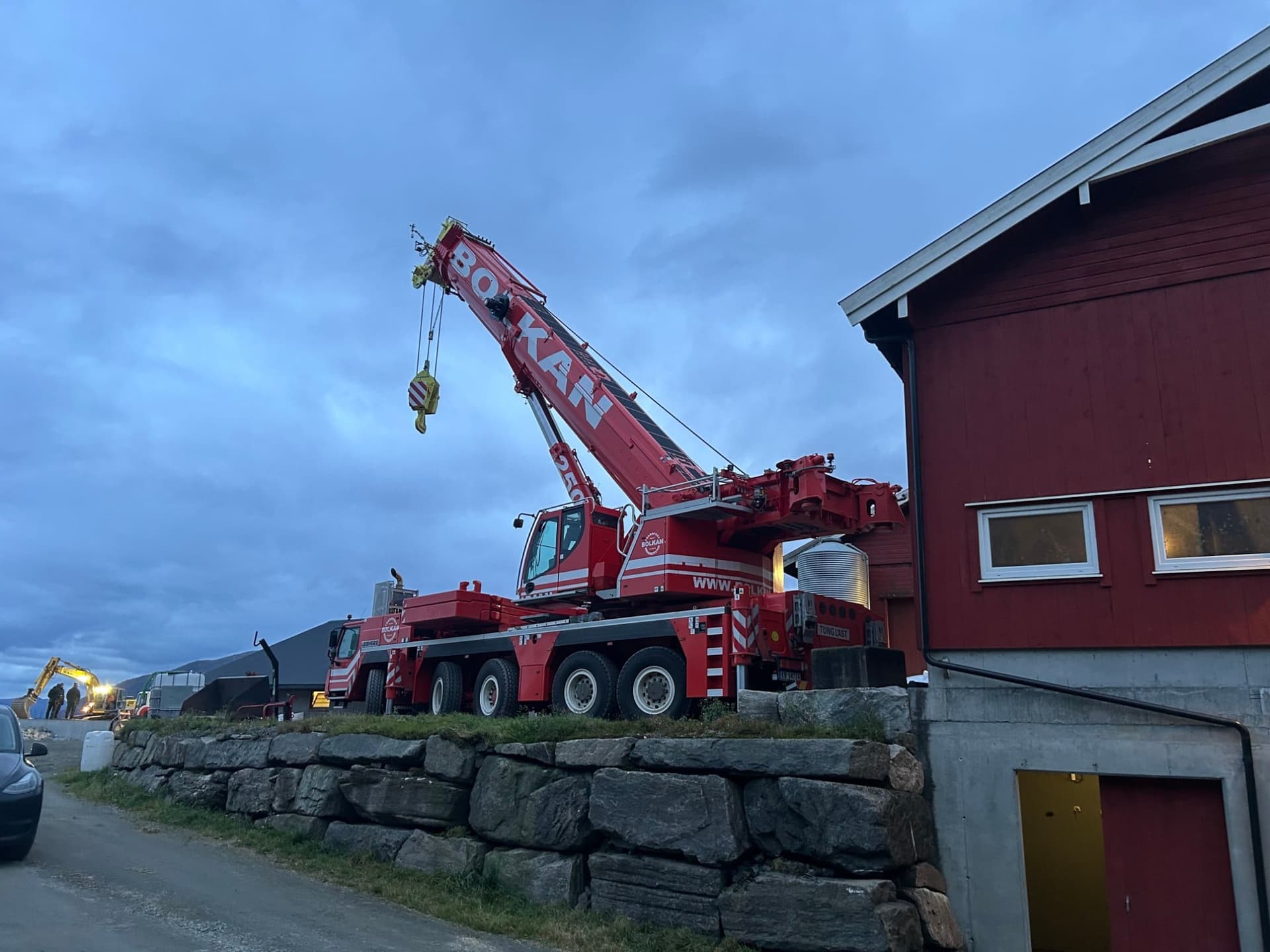 Bolkans 250-tonns mobilkran rigget opp ved et rødt fjøs