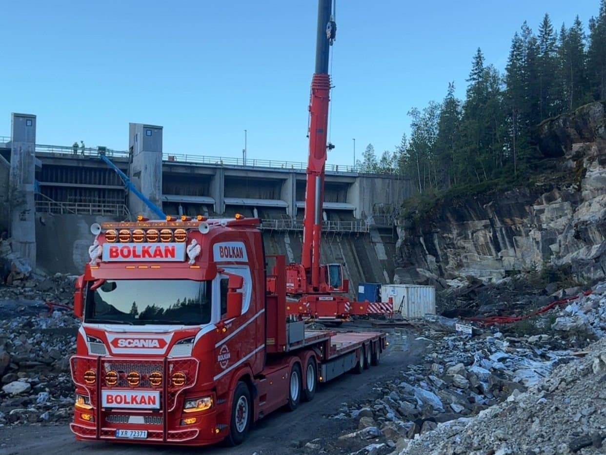 Bolkans mobilkran rigget opp ved en kraftverksdam, med en Bolkan Scania foran