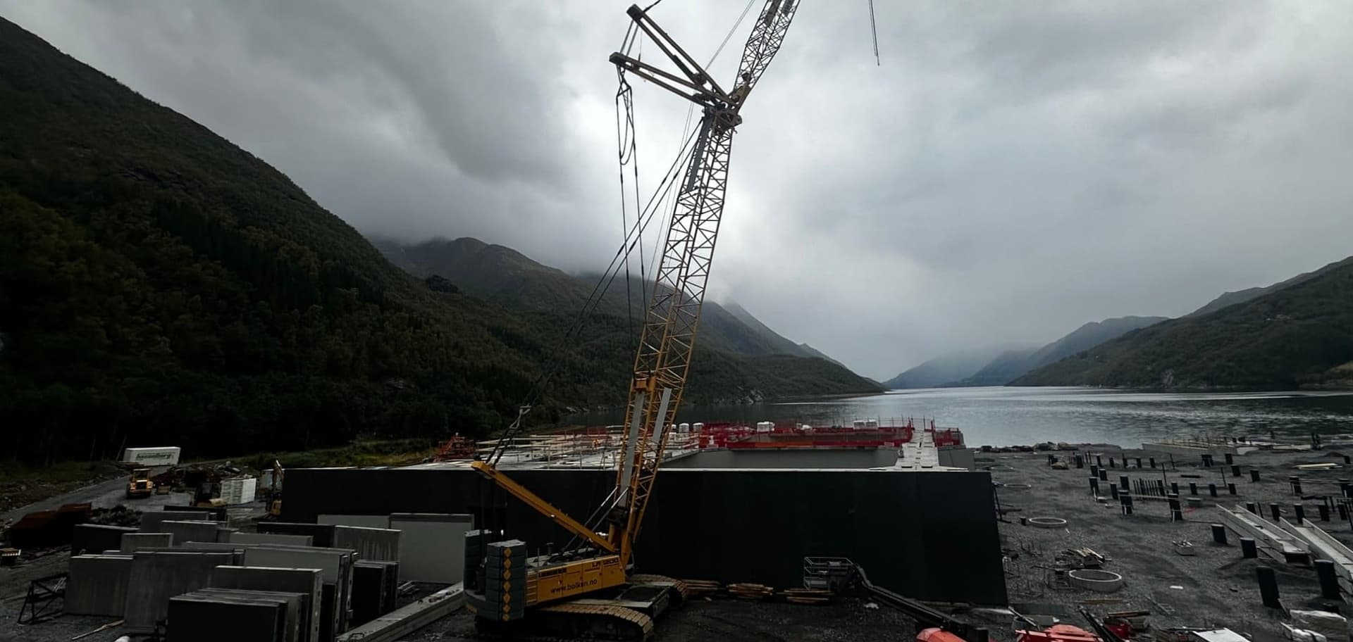Beltekranen Liebherr LR 1200 på et smoltanlegg ved en fjord i Nordland, med betongelementer og fjell rundt